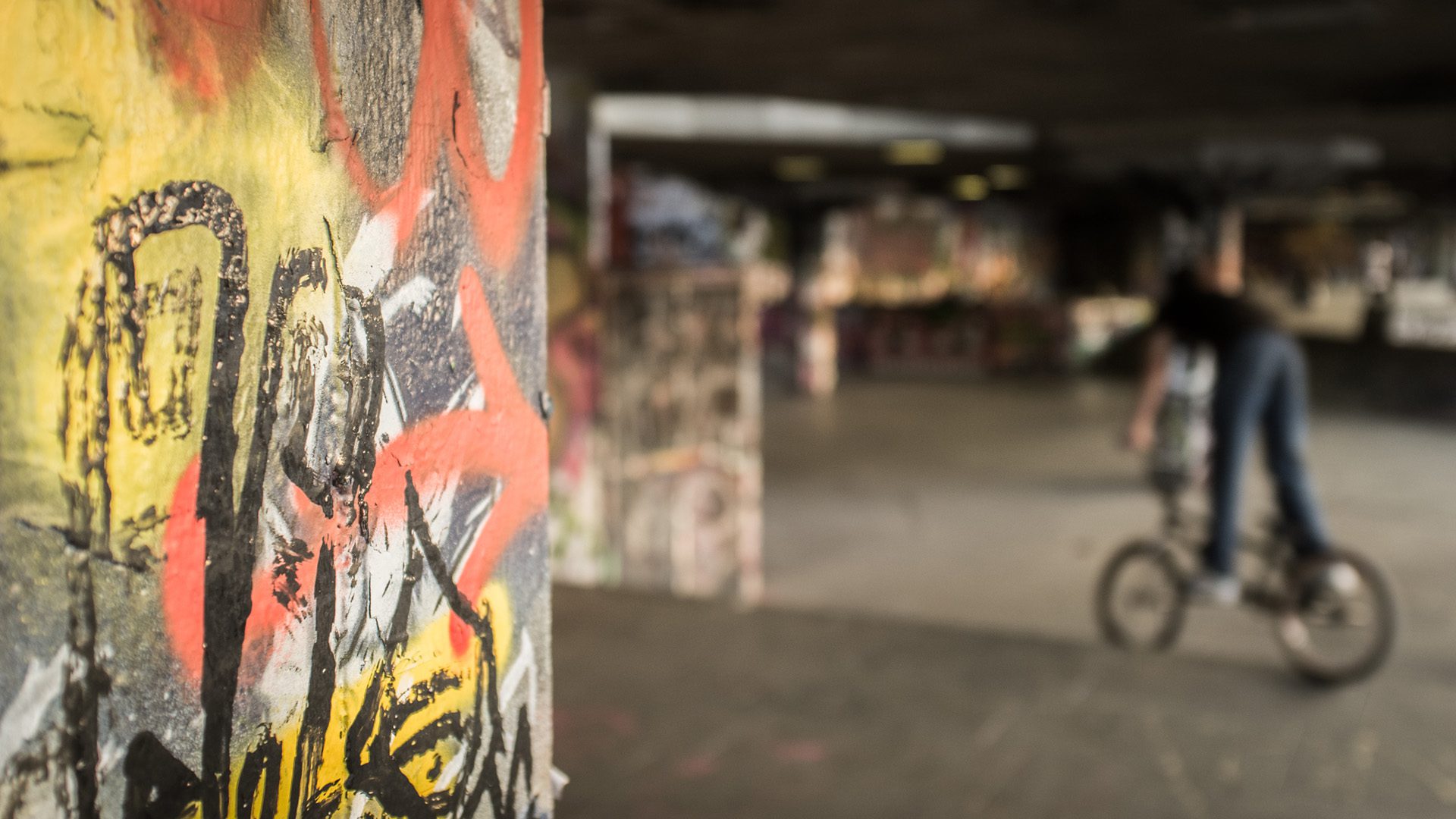 An urban concrete area adorned with graffiti and turned into a skate and BMX park in London, UK.